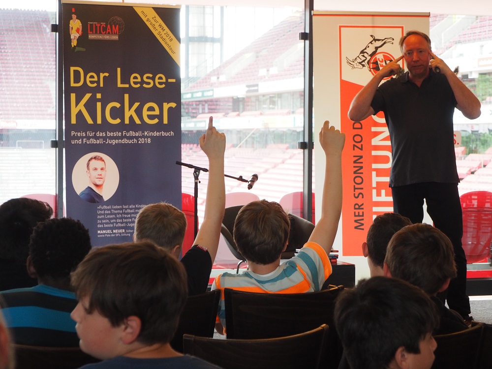 Ulf Blanck mit den Lese-Kicker-Kids im Rheinenergiestadion in Köln